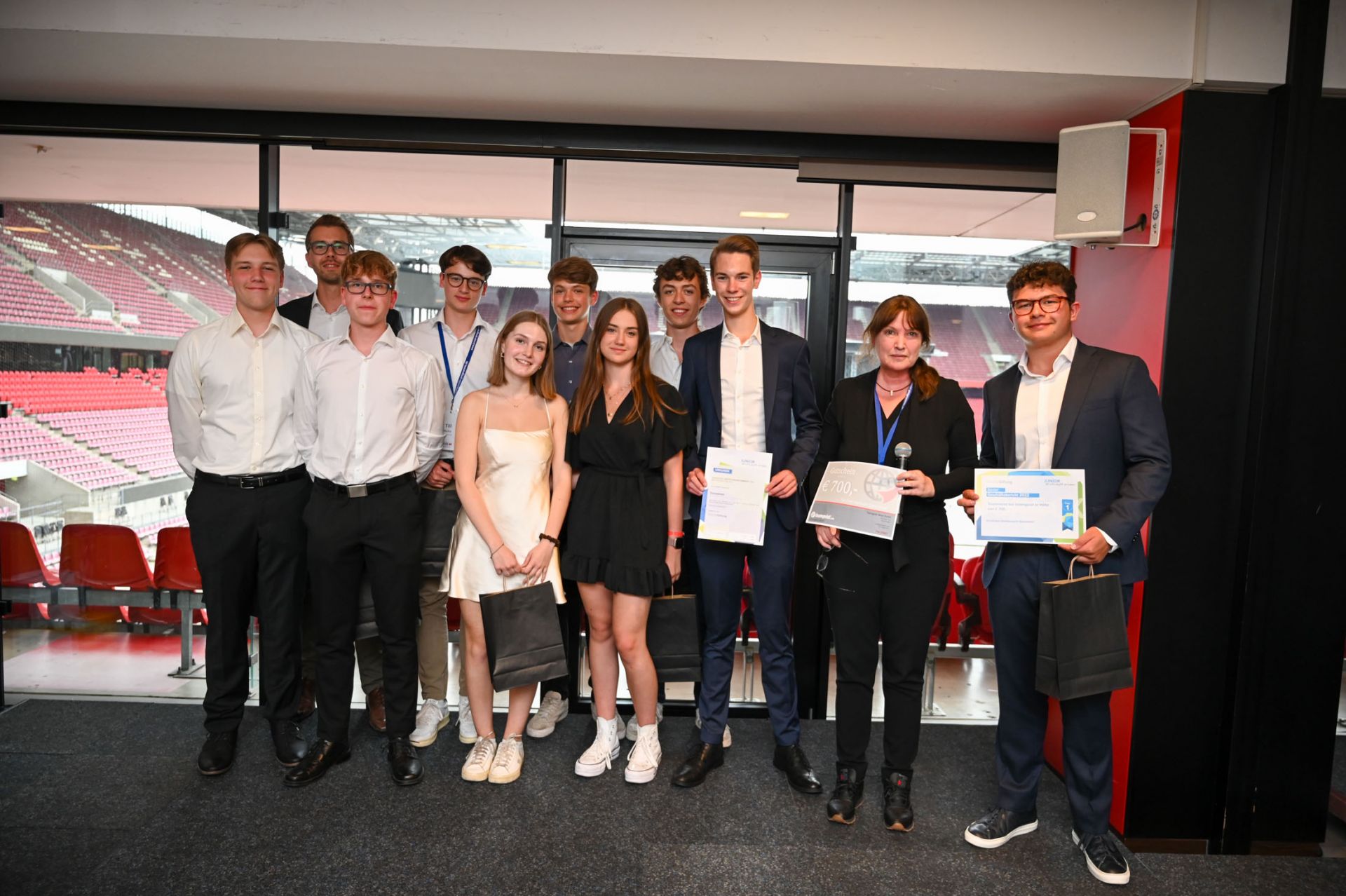 Zu sehen ist eine Schülerfirma bestehend aus 10 Jugendlichen, die den Deloitte-Sonderpreis "Bester Geschäftsbericht" von der Deloittevertretung erhalten